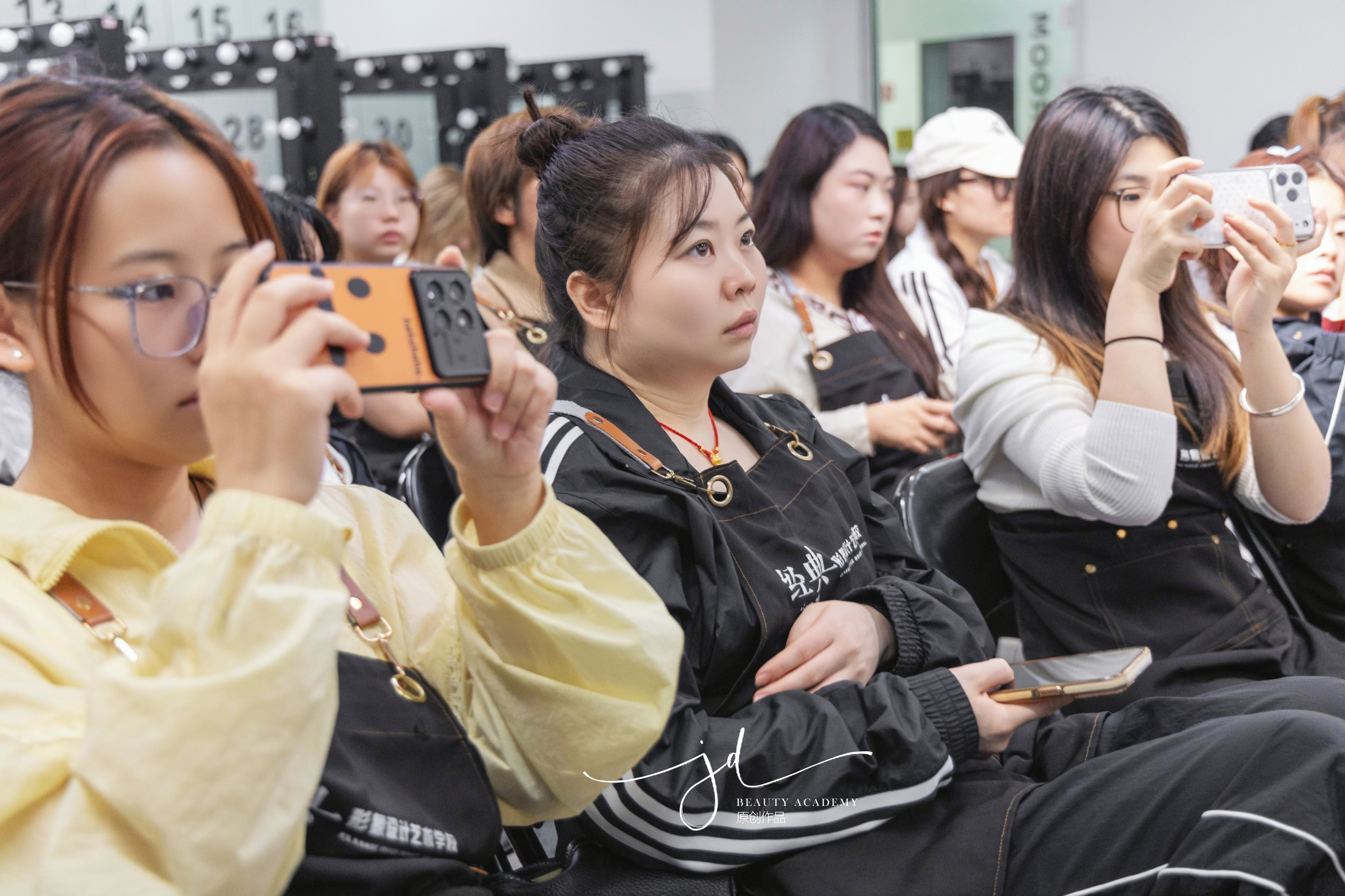 学员用手机拍摄课件认真记录